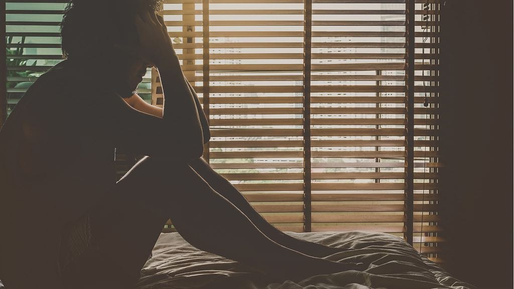 masentunut mies ikkunan edessä