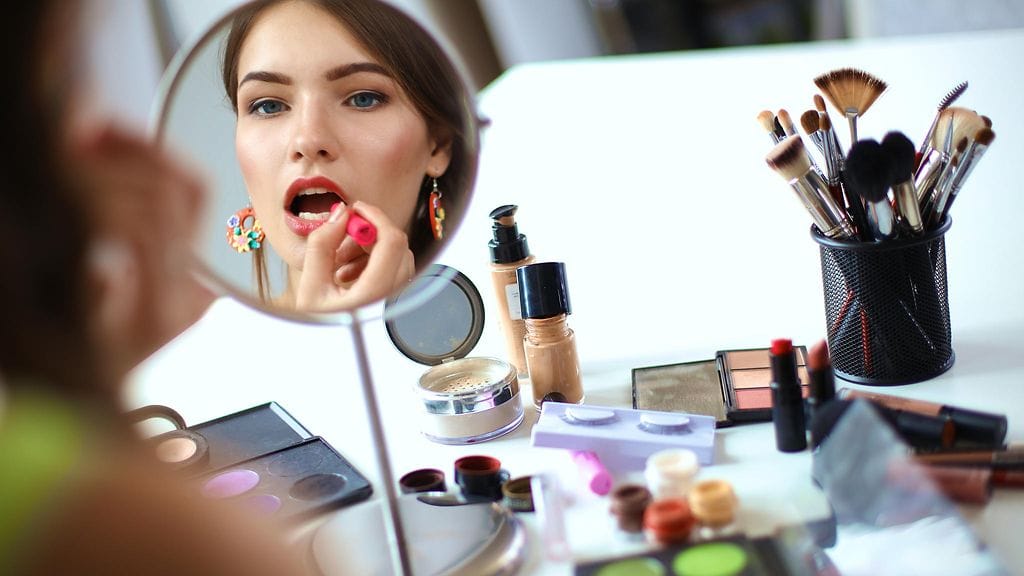 Meikkitaiteilija muistuttaa ihmisiä lisäämään meikkikerroksia maltillisesti.