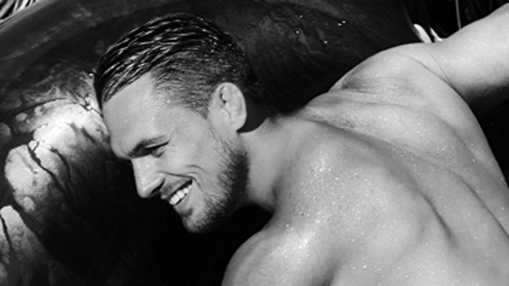 Kuumat urheilijamiehet riisuivat vaatteensa mieskalenterin sivuja varten.