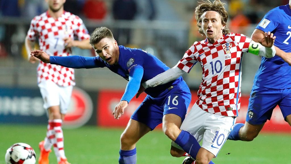 Luka Modric pallotaistelussa Suomen Simon Skrabbia vastaan.