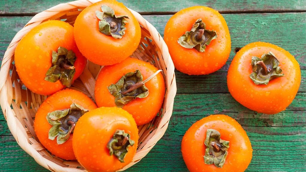 Kypsän persimonin tuntee kellertävän oranssista sävystä.