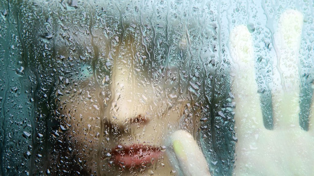 nainen ikkunan takana