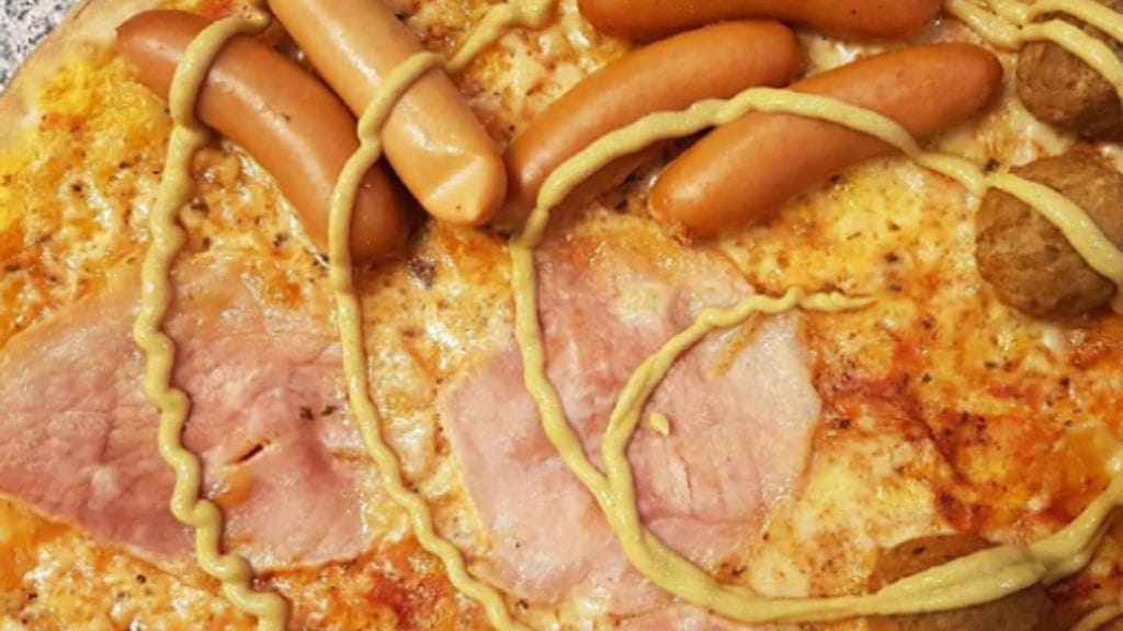 Joulupizzassa on kinkkua, prinssinakkeja, lihapullia ja sinappia.