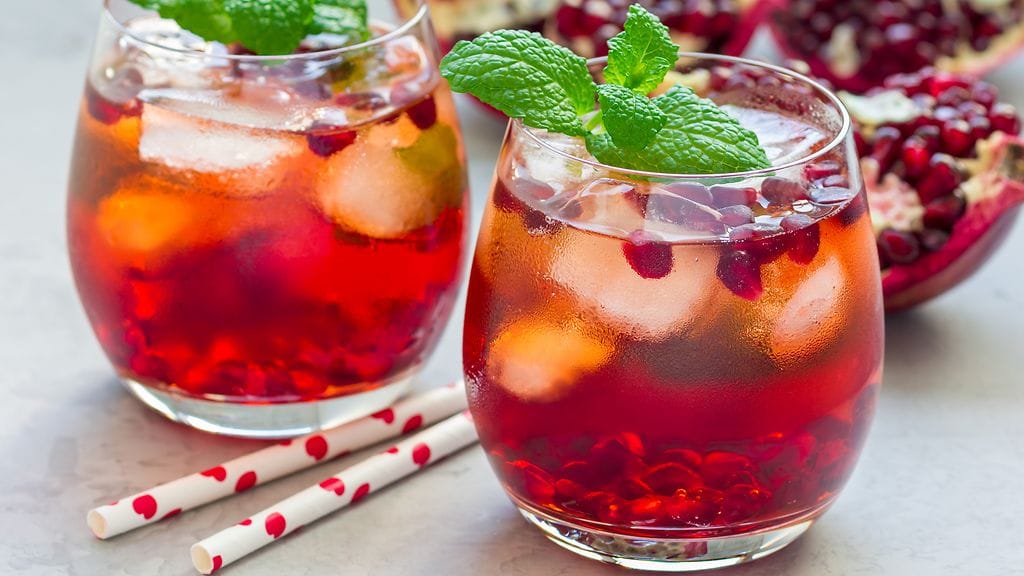 Jouludrinkissä yhdistyvät kuohuviinin kanssa omenat, granaatinomenan siemenet, viinipypäleet sekä karpalot. Kuvituskuva.