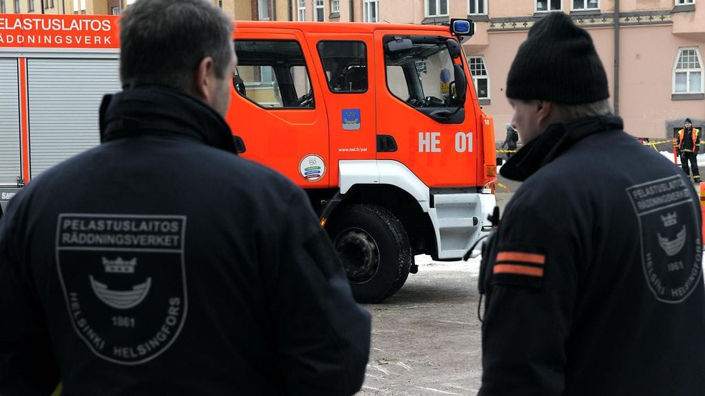 Kuvituskuvassa pelastusajoneuvoja Kallion pelastuslaitoksella Helsingissä.  Palomiehet tutkivat paloauton navigointia pienissä tiloissa.