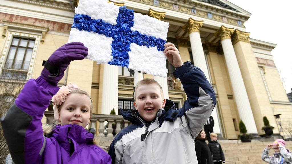 Miina Urpilainen (vas.) ja Miro Kinnunen esittelevät pääministeri Juha Sipilälle tekemäänsä korttia ennen juhlaa