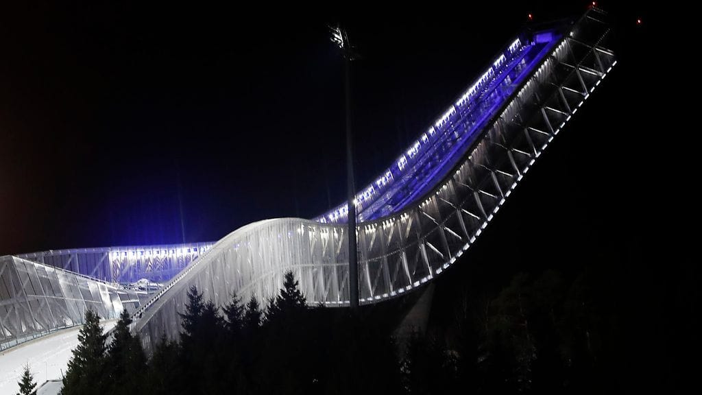 Holmenkollen valaistuna Suomen lipun väreihin.