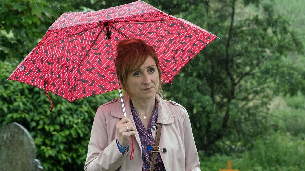 Laurel Thomasia näyttelevällä Charlotte Bellamylla on vaikeuksia sateenvarjonsa kanssa Emmerdalen poistetuissa kohtauksissa.