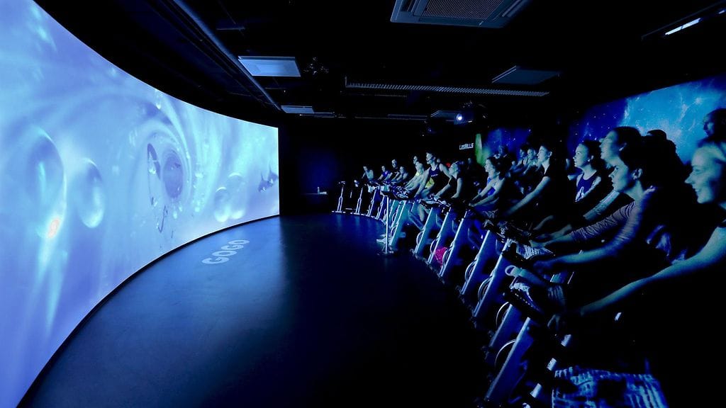 Kuntoilijat polkevat spinning-pyörillä virtuaalitodellisuutta hyödyntävän The Trip -liikuntalajin esittelyssä GoGo-liikuntakeskuksessa Tampereella 19. joulukuuta 2017.