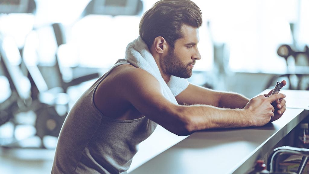 Menisitkö itse kuntosalille räpläämään puhelintasi vain, jotta kumppani luulisi sinun treenaavan? Kuvituskuva.