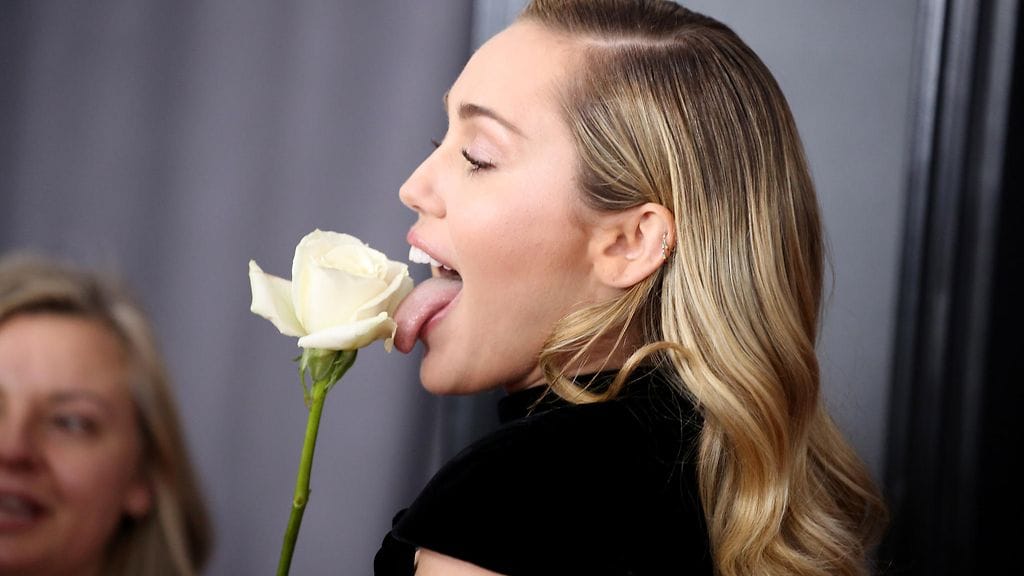 Miley Cyrus, valkoinen ruusu ja Miley Cyrusin kieli Grammy-gaalan punaisella matolla.