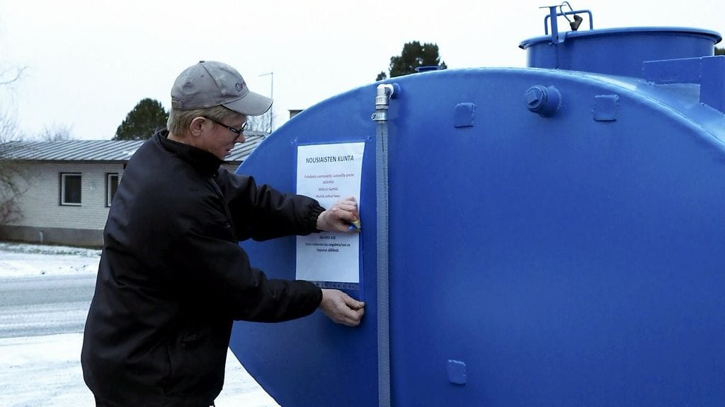 ousiaisten kunnanvaltuuston puheenjohtaja Reima Rantanen teippasi kylttiä vesitankkiin Nousiaisissa maanantaina 29. tammikuuta 2018. Nousiaisten keskustaan tuotiin asukkaiden käyttöön vesitankki vesijohtoveden saastumisesta johtuen.