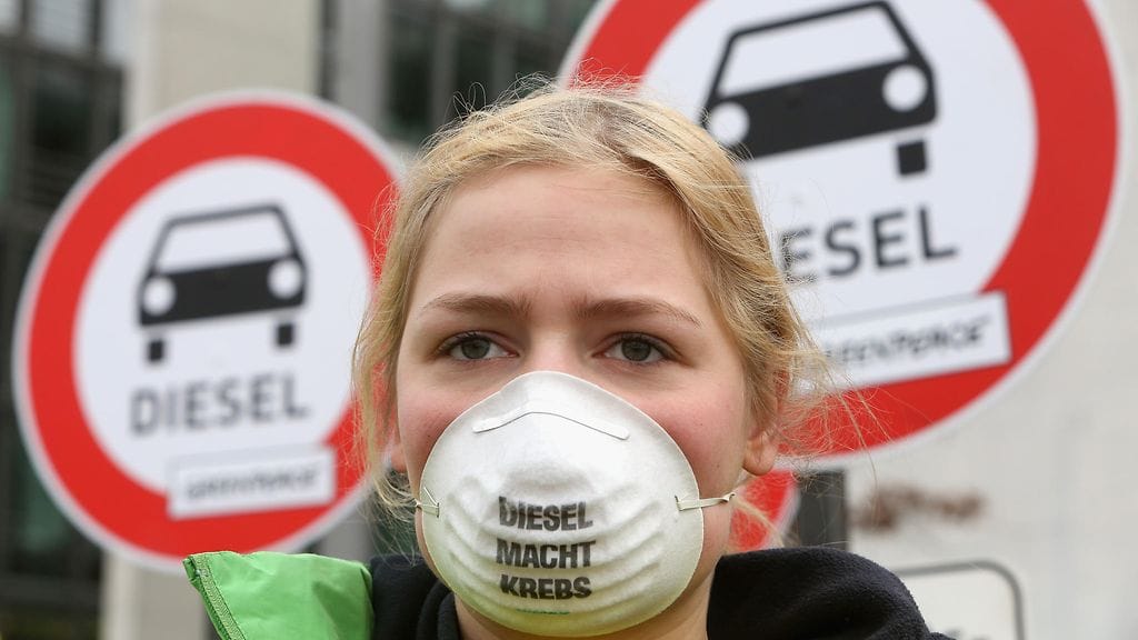 Volkswagenin dieselskandaali on saanut jatkoa sen jälkeen, kun paljastui, että se oli rahoittanut apinoilla testejä tehneen ryhmän toimintaa. Kuvassa Greenpeacen mielenosoittaja, jonka hengityssuojassa oleva teksti kertoo dieselin aiheuttavan syöpää.