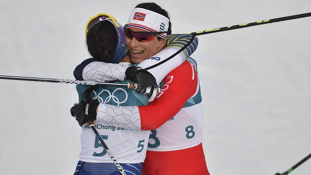 Marit Björgen (takana) ja Charlotte Kalla halasivat toisiaan yhdistelmähiihdon jälkeen.