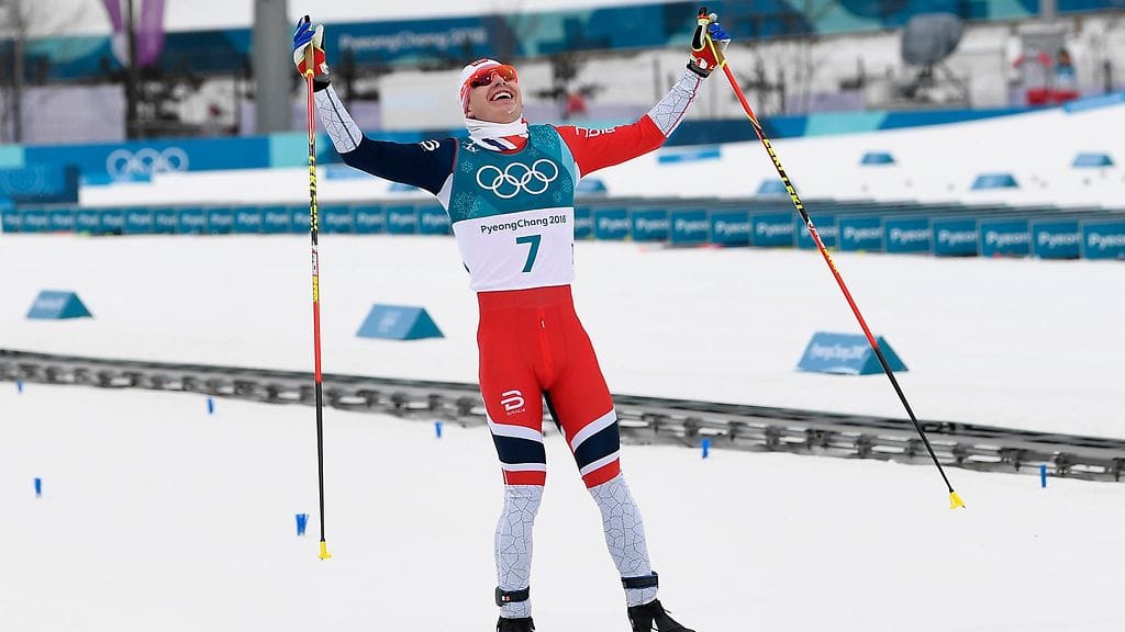 Simen Hegstad Krüger juhlii olympiavoittoa ylittäessään maaliviivan.