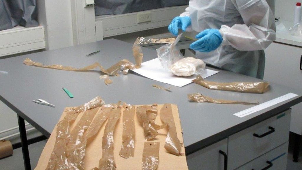 Huumepaketin purkaminen ja teippien irroittaminen tutkittavaksi on hidasta työtä. (Kuva: Itä-Uudenmaan poliisi)