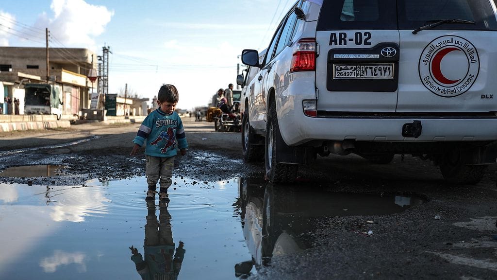 Arkistokuvassa lapsi leikkii vesilätäkössä Syyriassa.