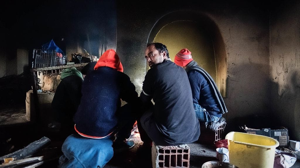 Ryhmä pakistanilaisia siirtolaisia lämmitteli nuotion äärellä hylätyllä maatilalla lähellä Unkarin rajaa Serbiassa 25. tammikuuta 2018.