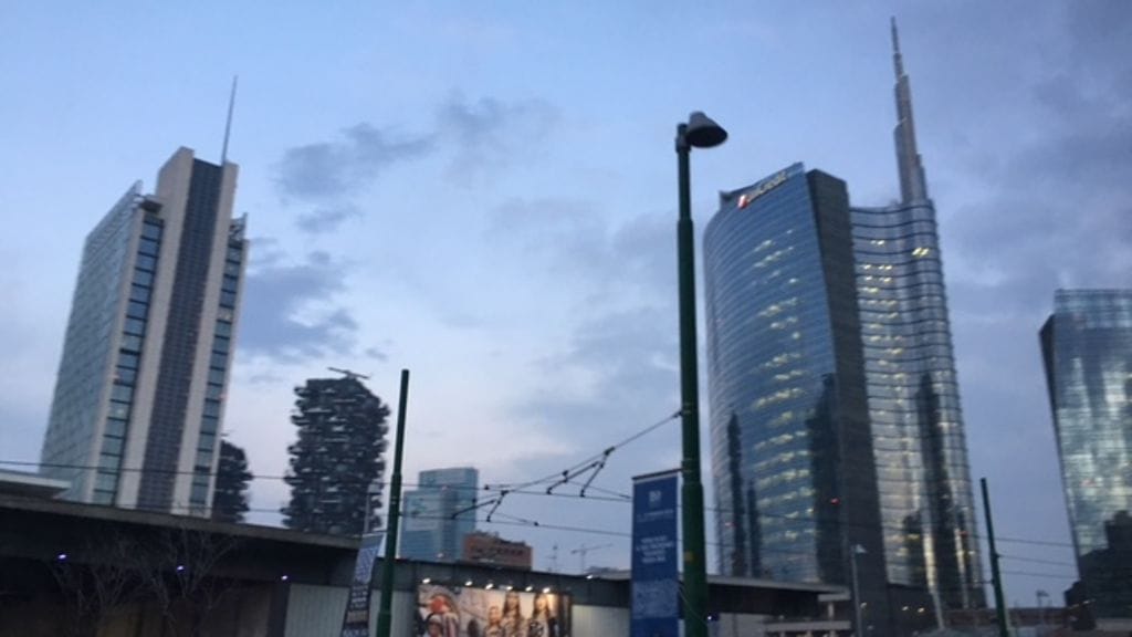 Pankkien pilvenpiirtäjien lasiseinät kiiltelevät Milanossa Pohjois-Italiassa. Köyhyys koettelee pahimmin maan eteläisempiä osia, mutta kodittomuus ja työttömyys tulevat vastaan myös Milanon vauraassa keskustassa.