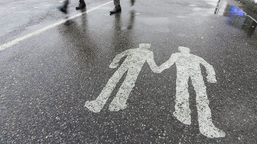 Miesparia esittävä jalkakäytävämaalaus Helsingissä.