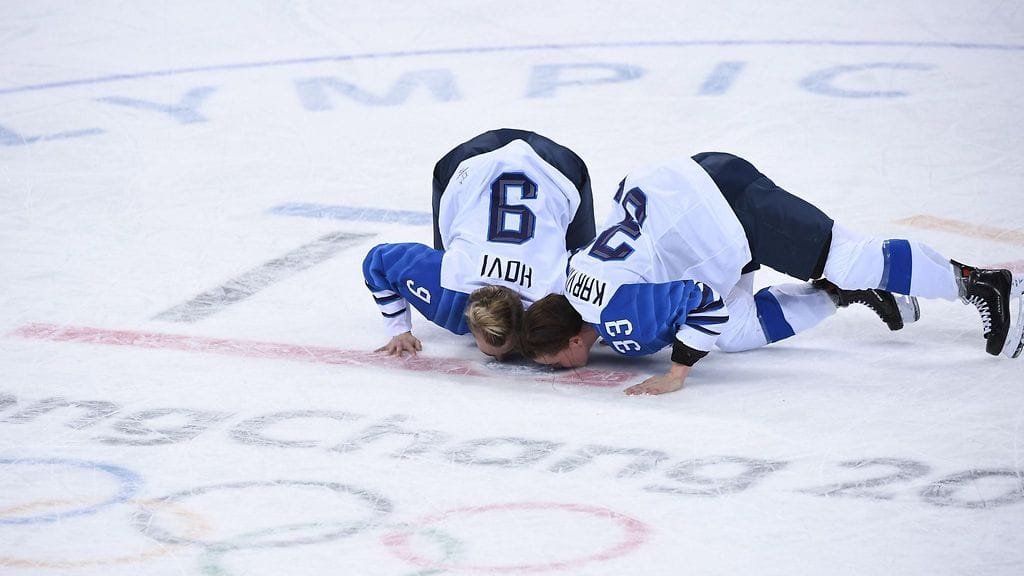 Naisleijonien Venla Hovi ja Michelle Karvinen suutelevat jäätä pronssiottelun ratkettua.