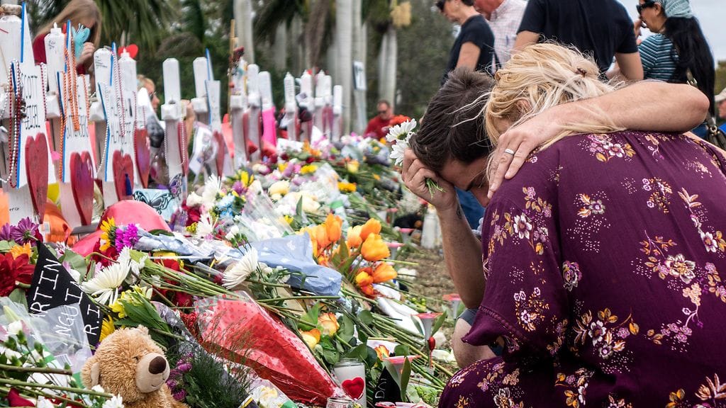 Ihmisiä suremassa Floridan kouluampumisen uhreja. Iskussa kuoli 17 oppilasta.