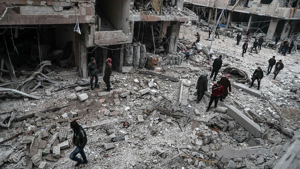 Ihmisiä tutkimassa pommitusten tuhoamaa aluetta Itä-Ghoutassa.