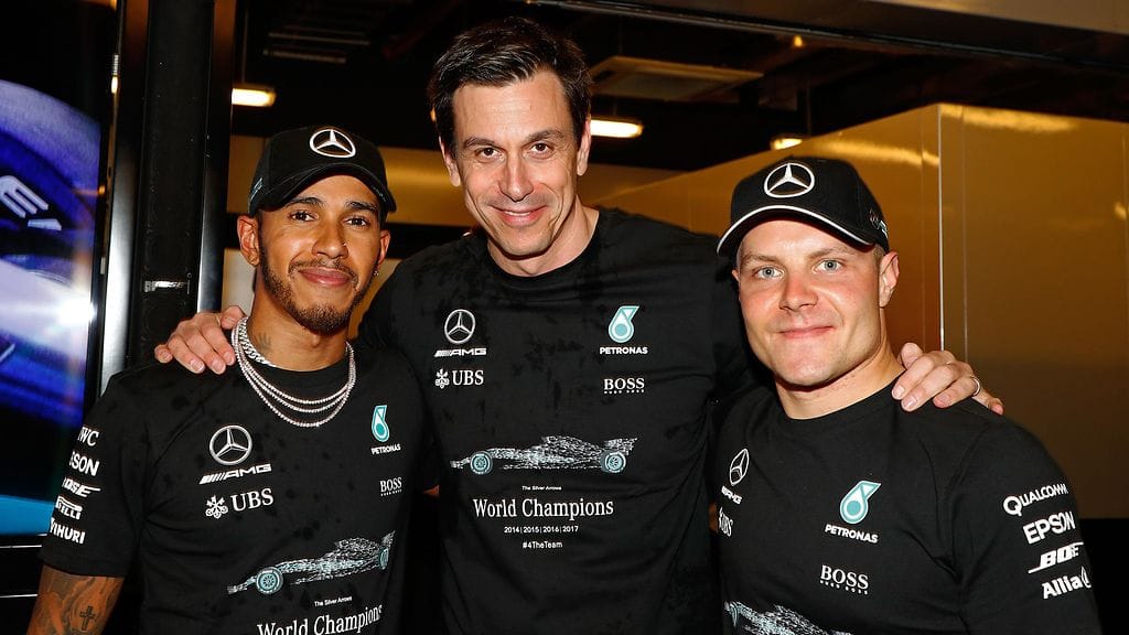Mercedeksen urheilujohtaja Toto Wolff (kesk.) poseeraa kuljettajiensa kanssa.