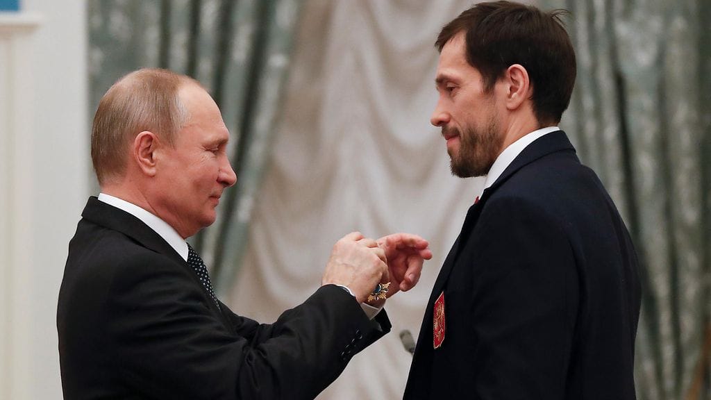 Venäjän presidentti Vladimir Putin jakamassa kunniamitalin venäläisten olympiaurheilijoiden miesten jääkiekkomaajoukkueen kapteenille Pavel Datsjukille.