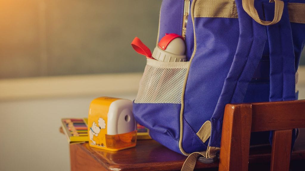 Pikkupojan reppu on yhtä iso kuin poika itse. Kuvituskuva.