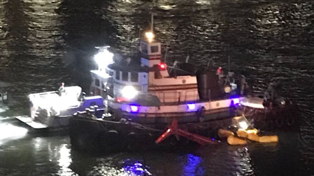Helikopterin sisälle jääneitä henkilöitä pelastetaan East River -joesta sen jälkeen, kun helikopteri syöksyi jokeen.