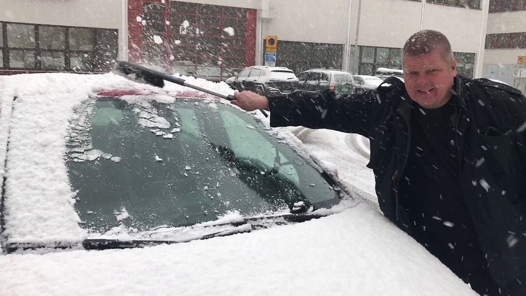Jarkko Sipilä puhdistaa autoa lumesta 2018
