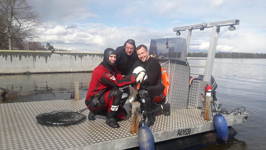 Kuvasssa pelastussukeltajat Juho Marjanen ja Joonas Mäkipelto sekä keskellä veneilijä Harri Sandvik.