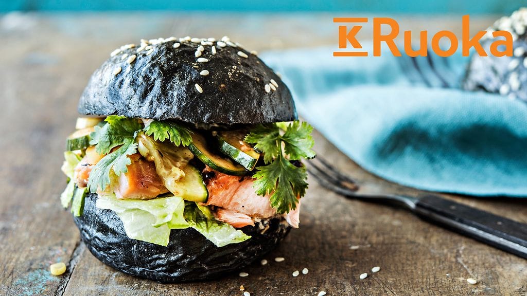 Korealainen lohiburgeri mustalla briossisämpylällä.