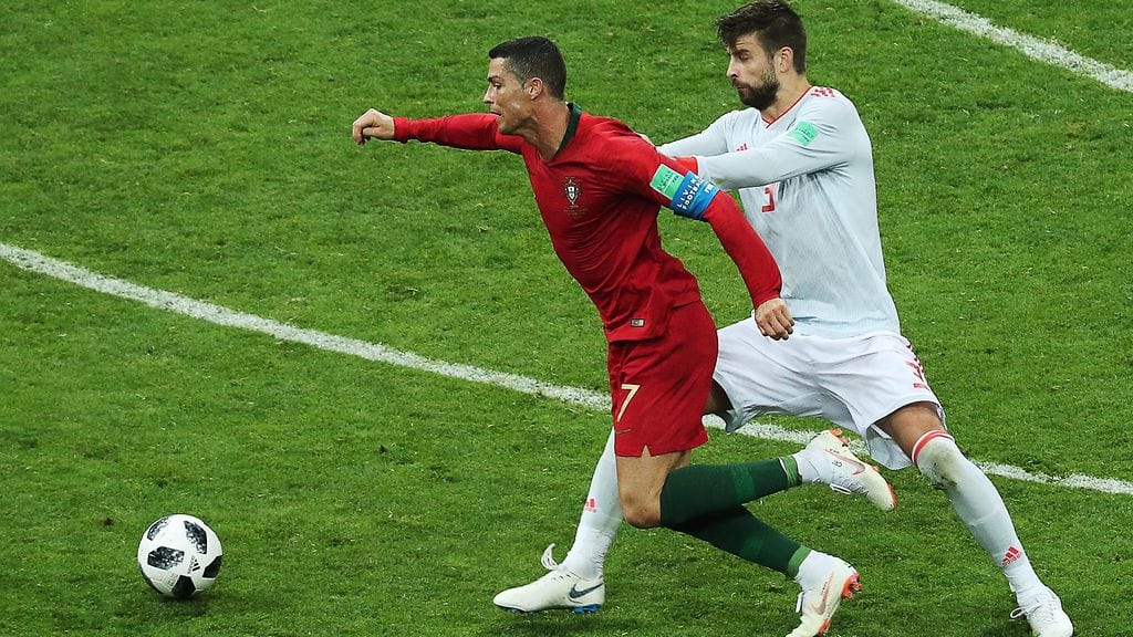 Cristiano Ronaldo ja Gerard Pique kaksinkamppailutilanteessa.