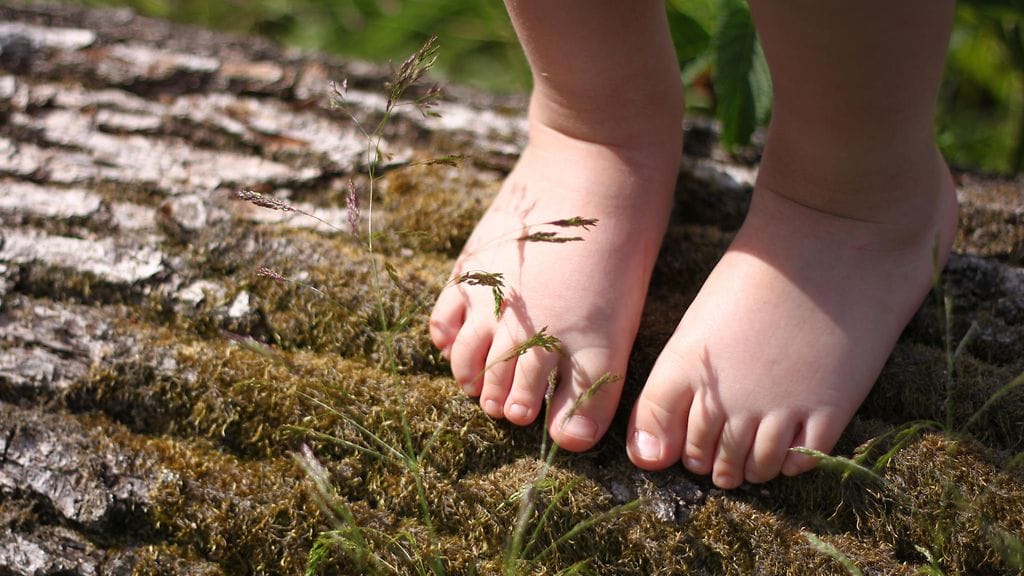 Rita antaa lastensa leikkiä paljasjaloin. Kuvituskuva.