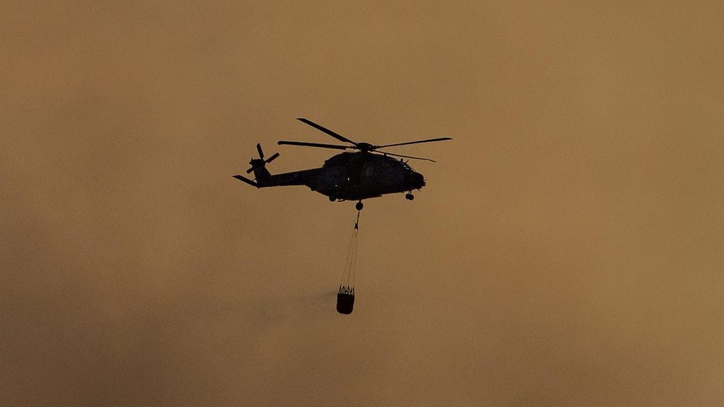 Kuva helikopterista, joka osallistuu viime viikolla riehuneen Pyhärannan maastopalon sammutuksiin.