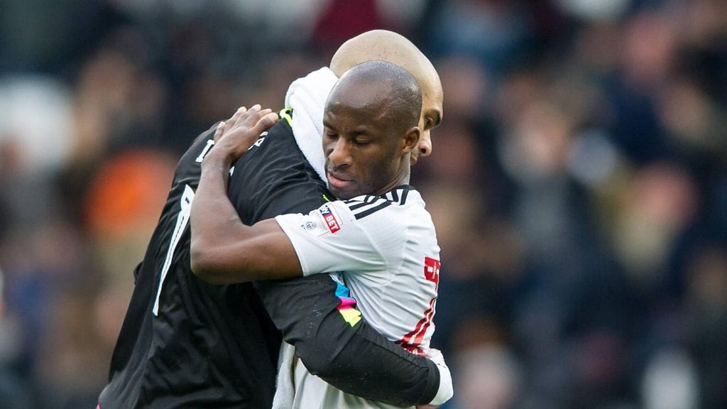 Arkistokuva. Wolverhamptonin maalivahti Carl Ikeme (takana) päättää ammattilaisuransa rankkojen syöpähoitojen vuoksi. Hän saa sosiaalisessa mediassa tukea. Halaamassa Sone Aluko.