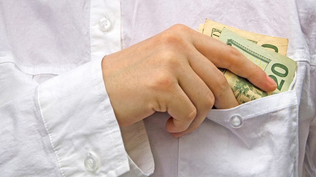 Tarjoilija laittoi ravintolan rahoja omaan taskuunsa. Kuvituskuva.