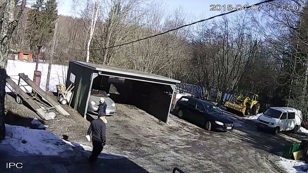 Poliisi sai talon valvontakamerat henkirikostutkinnassa. Kuvassa vaalea paketti viedään piiloon traktorin taakse.