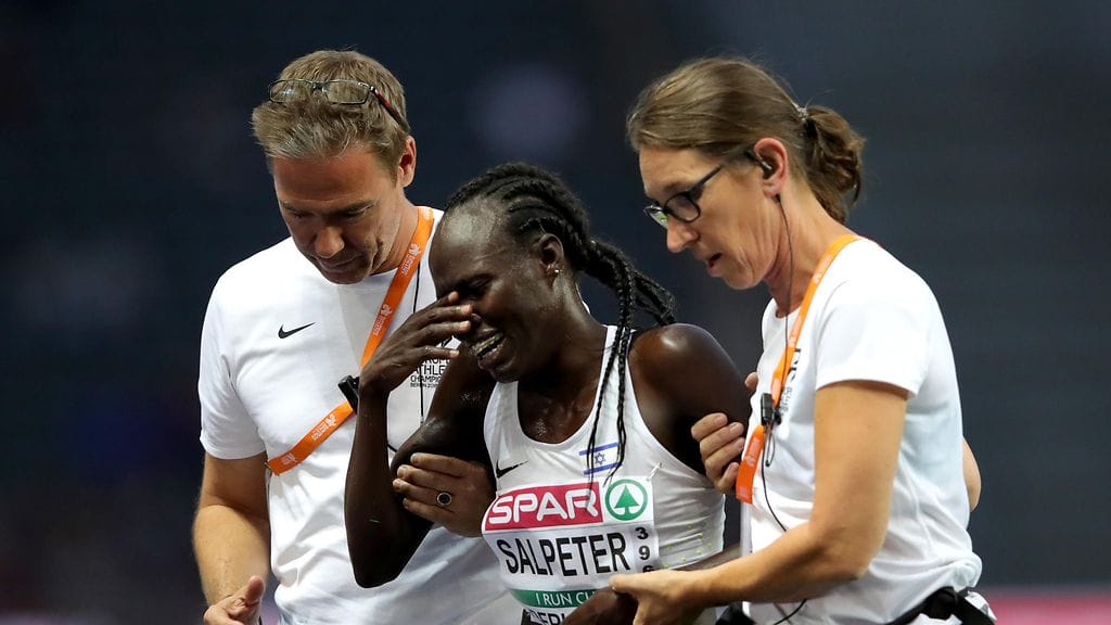 Kisajärjestäjät taluttavat pettyneen Lonah Chemtal Selpterin pois EM-stadionilta.