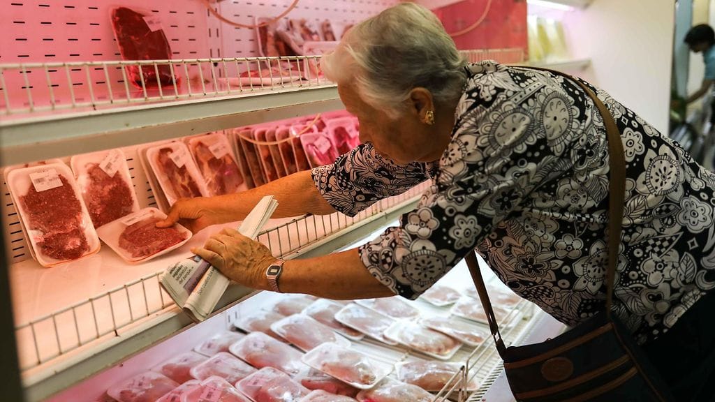 Nainen tutki lihan hintoja Venezuelan pääkaupungissa Caracasissa eilen. Korea inflaatio on tehnyt ruuan ostamisesta lähes mahdotonta monille.