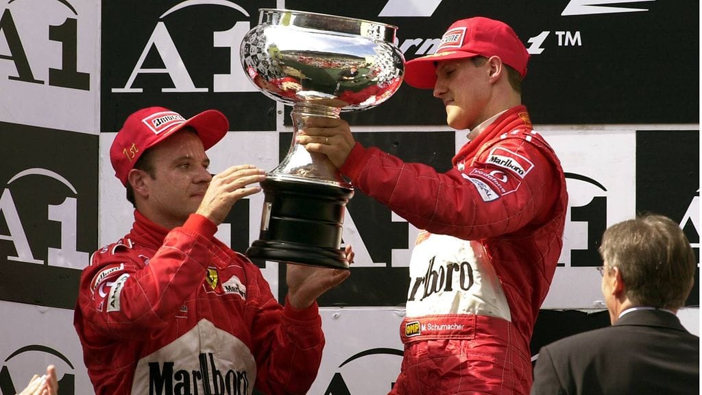 Michael Schumacher ojentaa voittopokaalin Rubens Barrichellolle vuonna 2002.