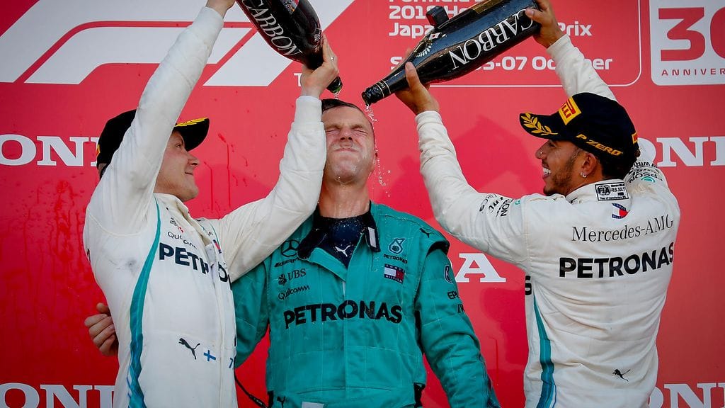 Valtteri Bottas ja Lewis Hamilton kylvettävät Mercedeksen tiimijäsentä kaksoisvoiton jälkeen.