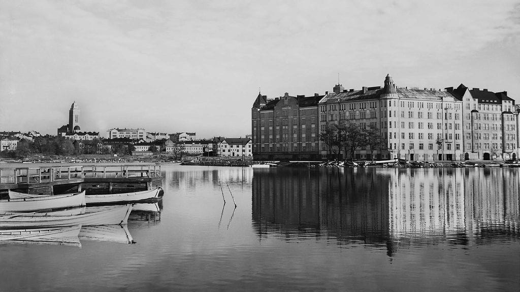 Talo on seissyt sijoillaan näyttävällä paikalla jo pitkään. Tuntemattoman valokuvaajan otoksessa vuodelta 1920 vasemmalla Eläintarhanranta (nyk. Tokoinranta). Oikealla Siltasaaren kärjessä vasemmalta lukien Säästöpankinranta 10, Pitkäsillanranta 17 ja Pitkäsillanranta 15. Kuva: Helsingin kaupunginmuseo.