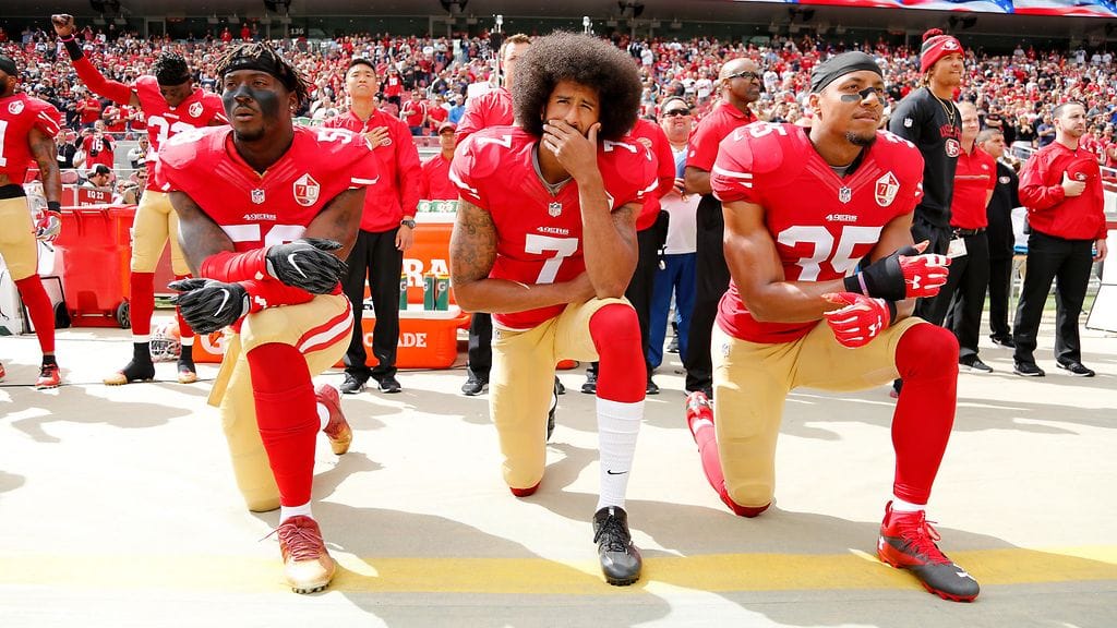 San Francisco 49ersien pelaajat Eli Harold (vas.), Colin Kaepernick (kesk.) ja Eric Reid (oik.) polvistuivat kansallislaulun ajaksi lokakuussa 2016.