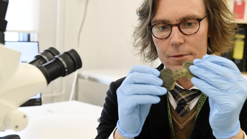 Suomen kansallismuseon intendentti, konservointiyksikön päällikkö Eero Ehanti hanti kädessään Sastamalasta löydetty, konsertoivana oleva solki Vantaalla 28. syyskuuta 2018.