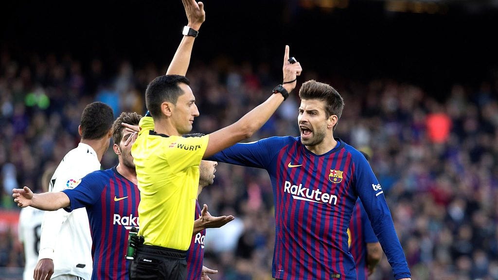 Barcelonan Gerard Piquellä on asiaa ottelun erotuomarille pilkkutilanteesta.