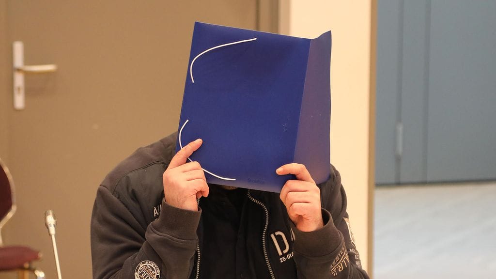 Niels Högel peitti kasvonsa kuvaajilta oikeussalissa.