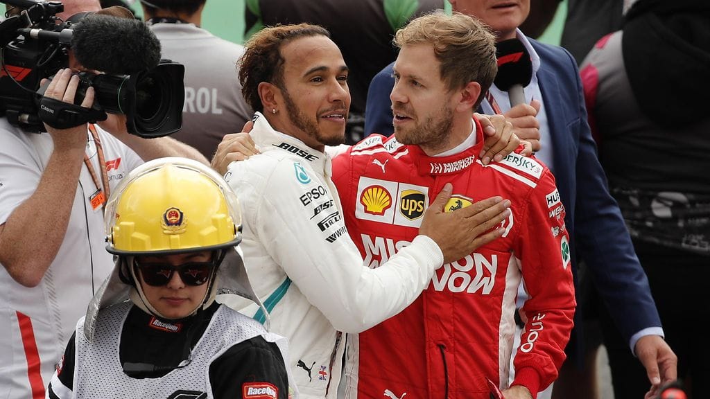 Mercedeksen Lewis Hamilton sai onnittelut Ferrarin Sebastian Vetteliltä varmistettuaan uransa viidennen formula ykkösten maailmanmestaruuden.